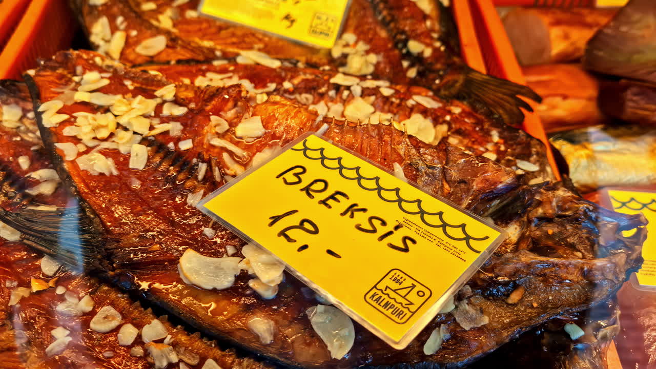Smoked bream with garlic slices for sale at food market display