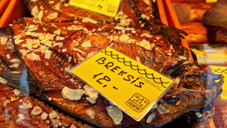 smoked bream with garlic slices for sale at food market display