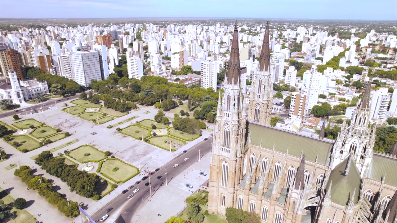 4K drone aerial view of La Plata Cathedral in Buenos Aires, Argentina. The iconic Gothic revival cathedral overlooking Plaza Moreno, surrounded by historic architecture and the urban landscape of the