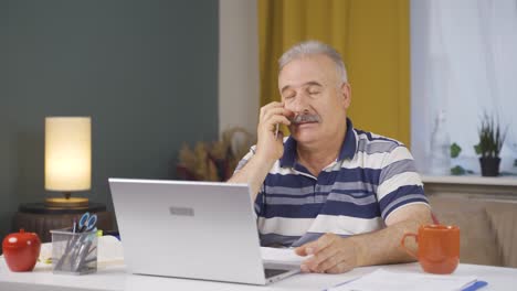 trabajador de oficina en casa anciano hablando por teléfono felizmente.