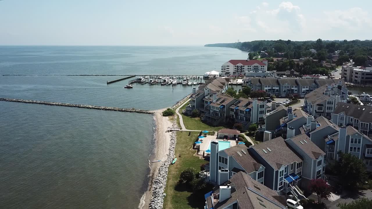 Cinematic Aerial of Chesapeake Bay Beach Properties, Jetty and Boats in Marina on Sunny Summer Day