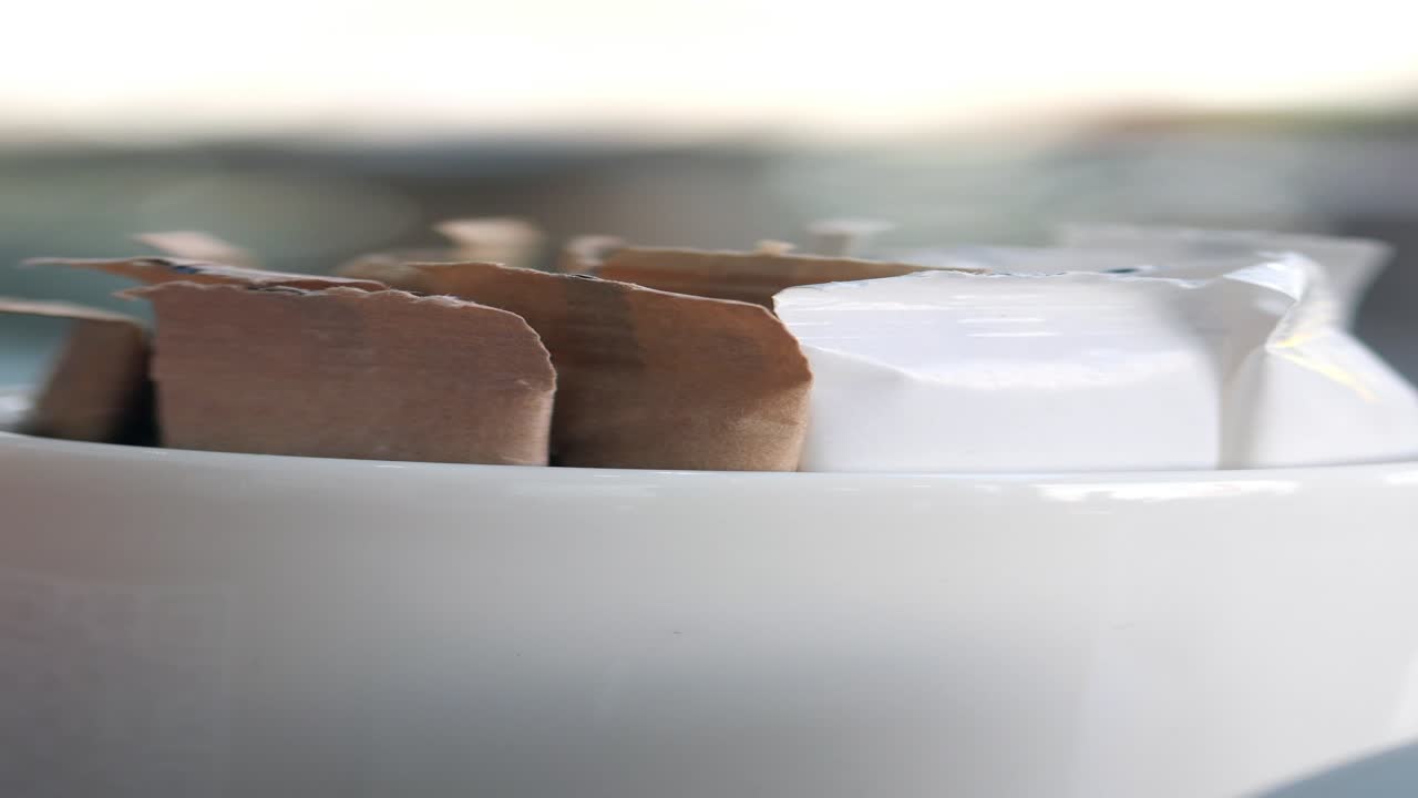 cerca de paquetes de azúcar y una taza blanca