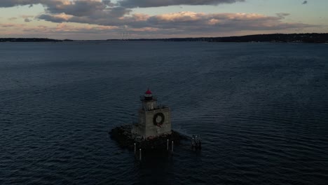 an aerial view of the huntington harbor lighthouse on long island, ny at sunset, with a christmas wreath