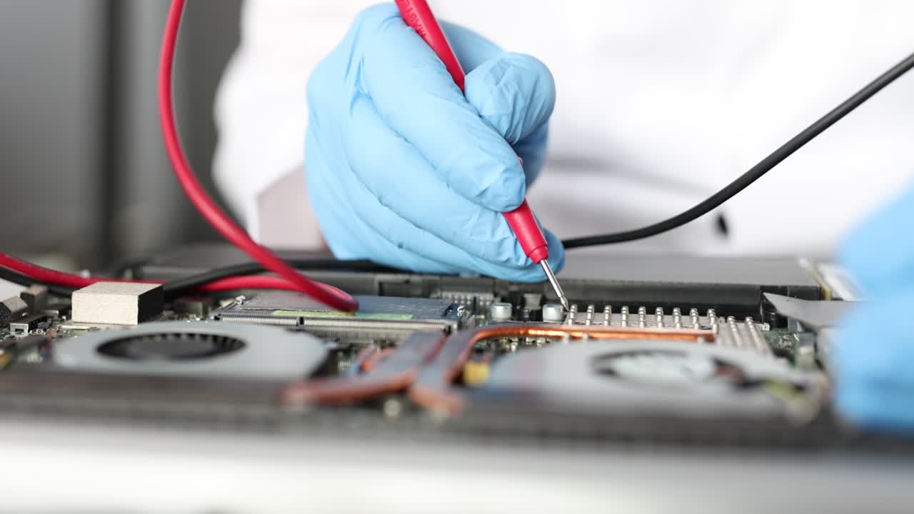Technician Diagnosing Laptop Motherboard with Multimeter