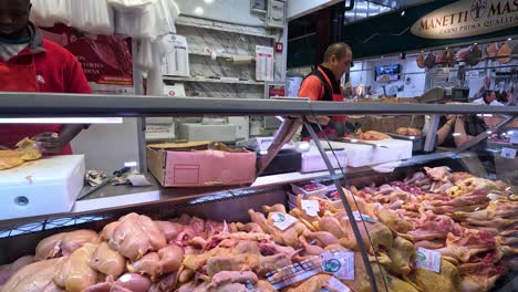 un carnicero preparando pollo en el puesto del mercado de florencia.