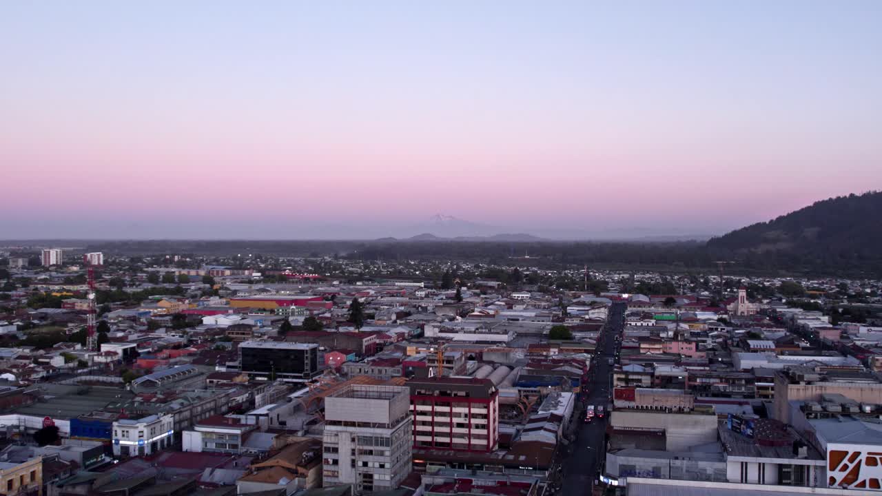 Aerial view establishing the city of Temuco with the blue hour and purple colors, Llaima volcano