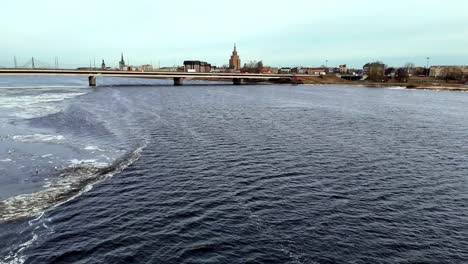 aerial of bridge pver daugava, spans a river with a riga city in the background