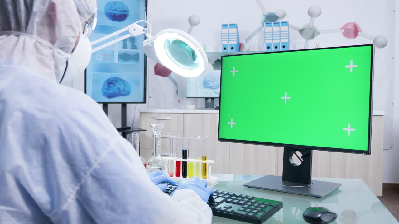 Scientist working in a lab with green screen computer