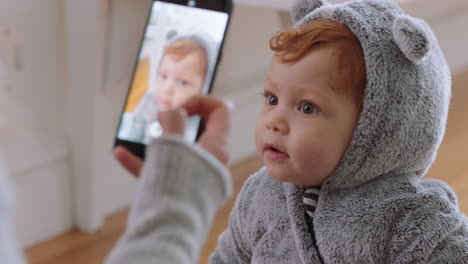 Madre-Tomando-Una-Foto-Del-Bebé-Usando-Un-Teléfono-Inteligente-Disfrutando-Fotografiando-A-Un-Lindo-Niño-Pequeño-Compartiendo-El-Estilo-De-Vida-De-La-Maternidad-En-Las-Redes-Sociales