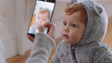 madre tomando una foto de su bebé usando un teléfono inteligente disfrutando de fotografiar a un bebé lindo compartiendo el estilo de vida de la maternidad en las redes sociales