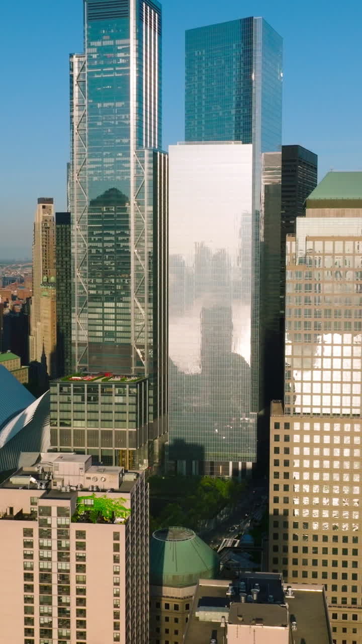 Diverse buildings and skyscrapers of Lower Manhattan Financial District in the sun light. New York city architecture at the backdrop of blue clear sky. Vertical video