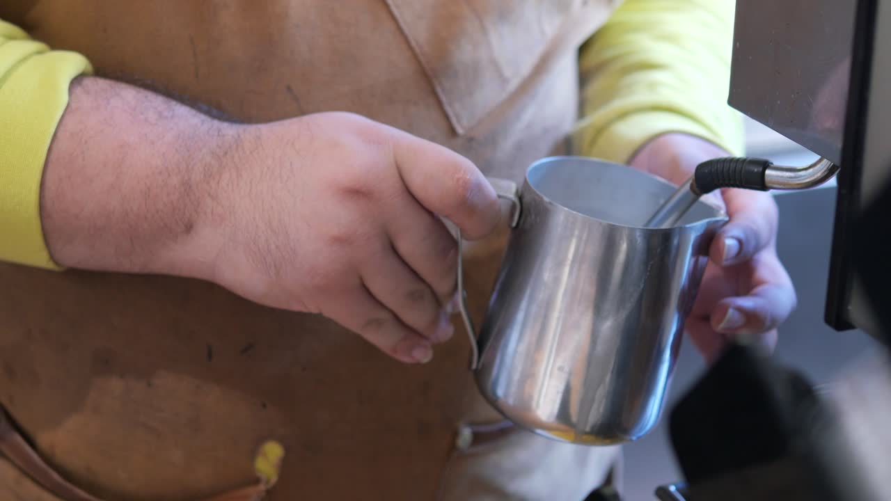 barista vaporizando leche para la bebida de café