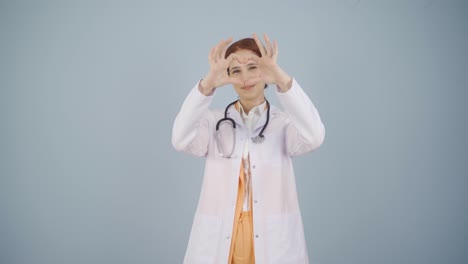 doctor making heart looking at camera.