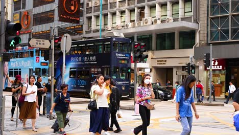 people crossing a bustling street in hong kong