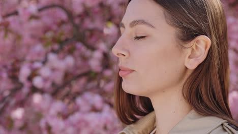 woman using nasal spray outdoors amongst cherry blossoms
