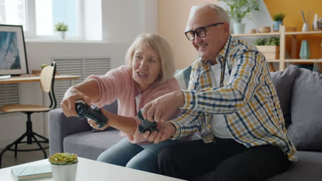 una pareja de mayores feliz jugando videojuegos.
