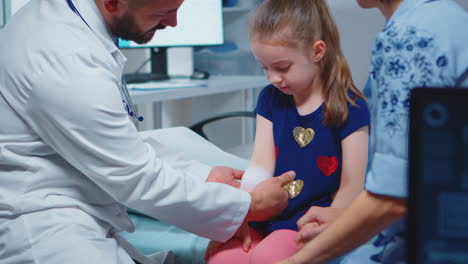 Little-girl-having-arm-bandaged