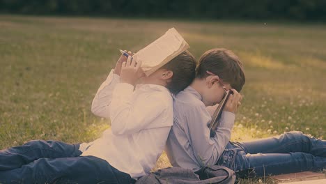 exhausted boys sleep with books in hands preparing for exam