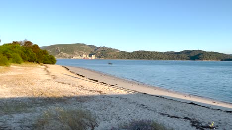 Boot-Vor-Anker,-Treibend-In-Einem-Ruhigen-Und-Friedlichen-Ozean-Mit-Setúbal-Im-Hintergrund