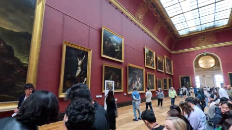 crowd observing paintings in louvre museum, paris