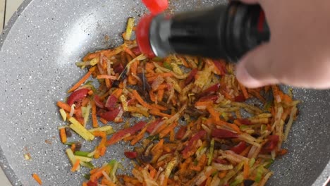 Mano-De-Hombre-Añadiendo-Salsa-De-Soja-Para-Freír-Verduras-En-Un-Wok