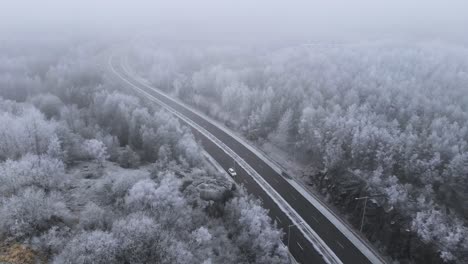 icy sweden highway road in the wintertime - aerial establishing