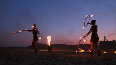 fire show. a group of professional artists performs a variety of fire facilities. boys and girls performed dances with fire in the night on the street in the park.