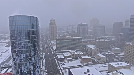 snowy aerial past hyatt regency building with view down south temple street, slc