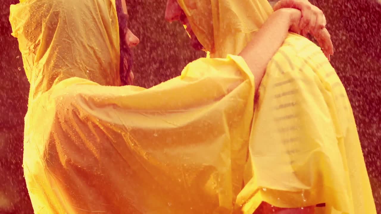 비가 내리는 동안 공원에서 포옹하는 행복한 커플