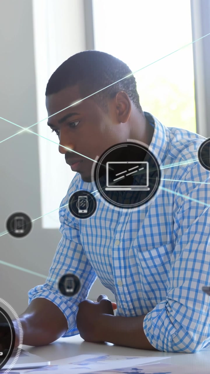 Vertical video: Man reading papers at table, chest icon appearing, forming laptop or phone web for b