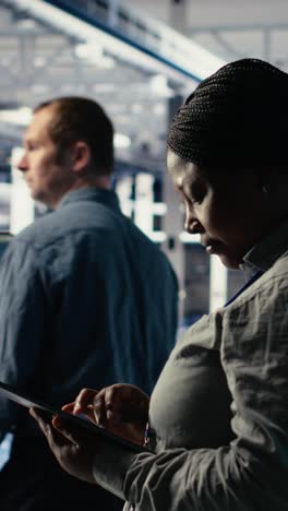 vertical video team of data center technicians checks ai dashboard using laptop