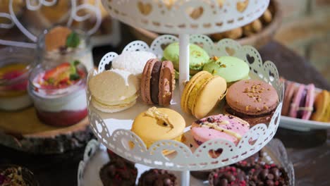 close-up shot of wedding dessert with macarons, muffins, pastries, cupcakes, and cakes