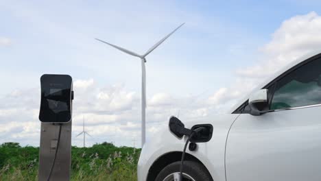 progressive combination of ev car, charging station and wind turbine.