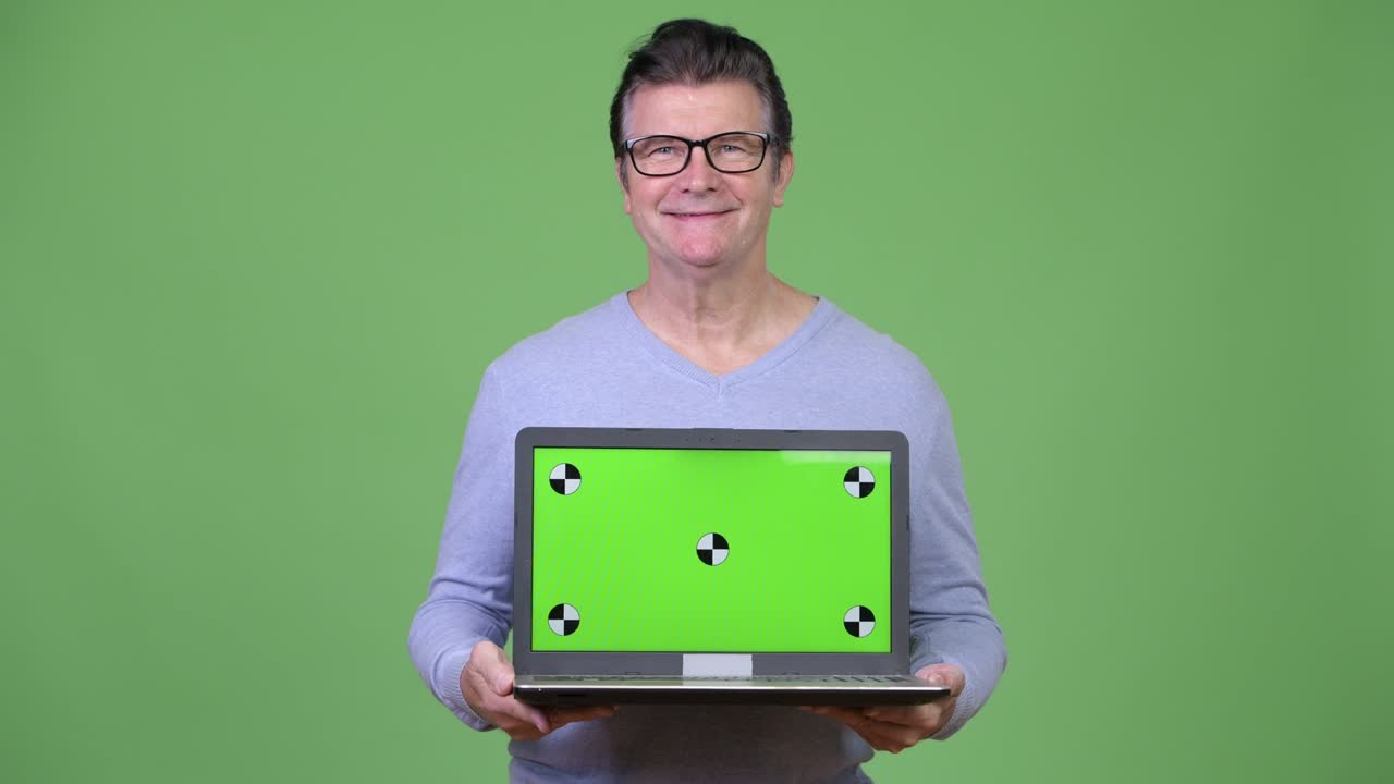 Senior handsome man showing laptop