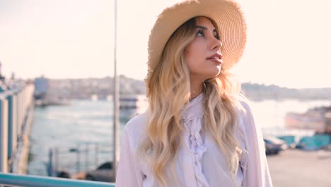 beautiful girl poses near bosphorus with view of galata bridge and istanbul