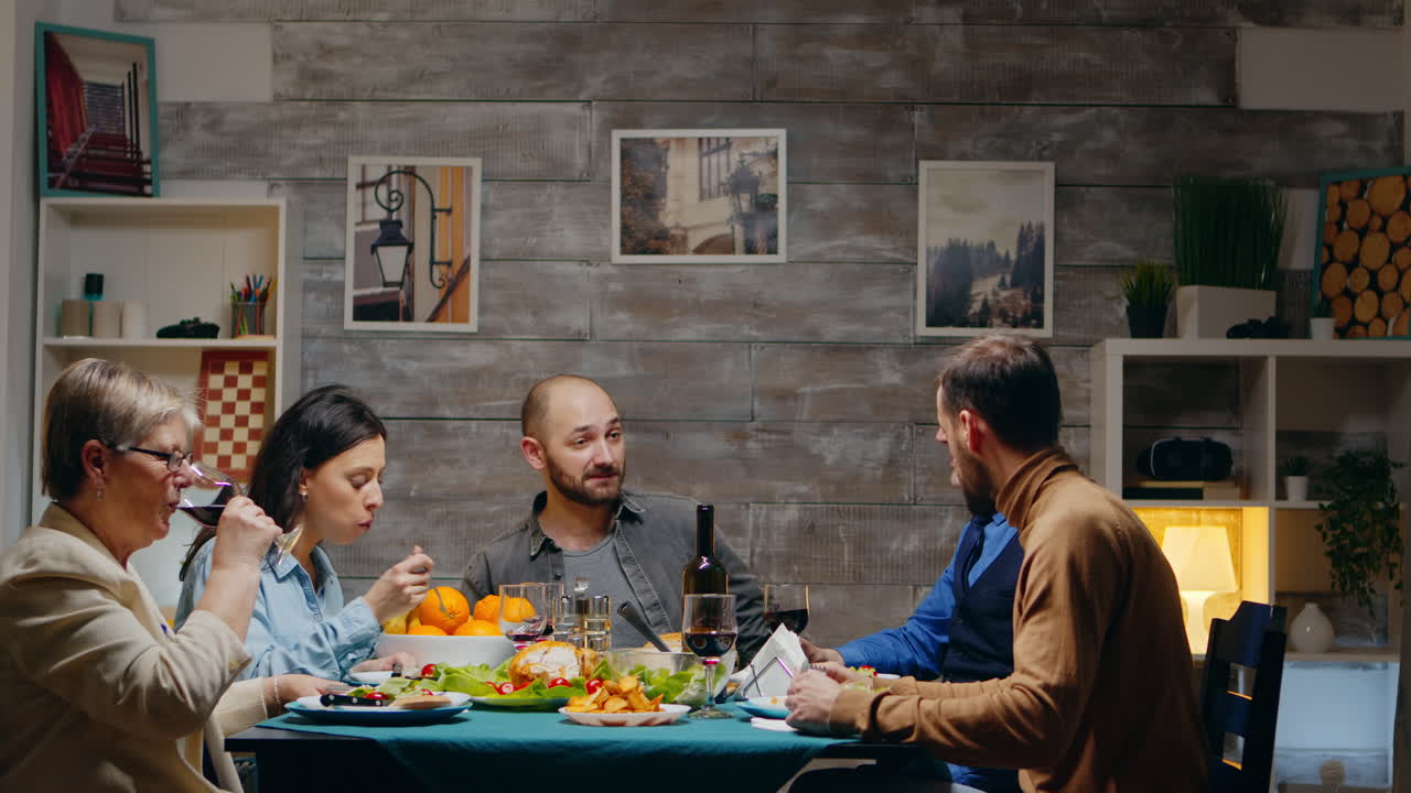 un hombre y una mujer de sesenta años bebiendo un vaso de vino tinto.