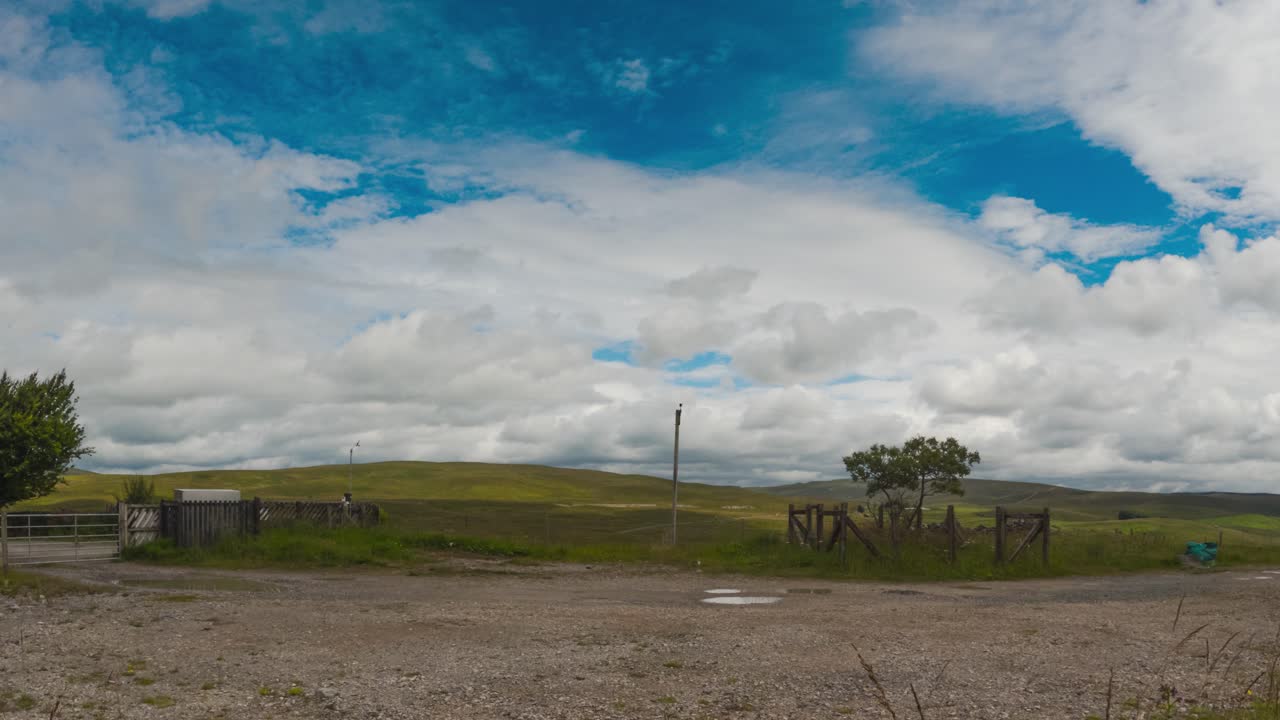 las nubes rodan sobre una tranquila estación de tren rural en un día brillante y parcialmente nublado, timelapse