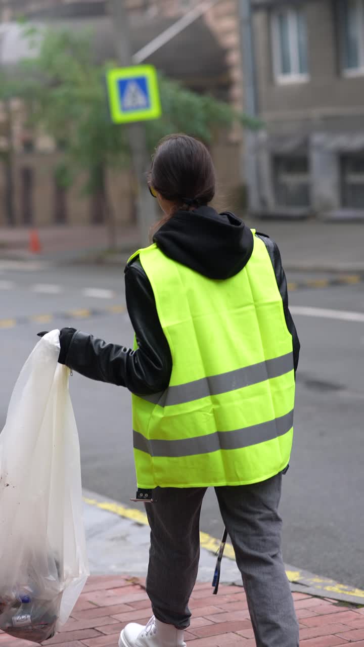 mujer limpiando la basura en la calle