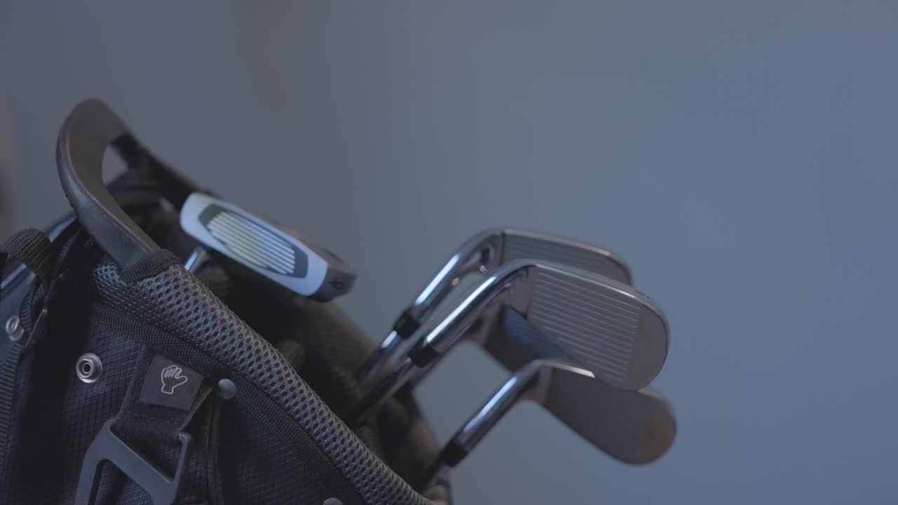 golfer removing his 6 and 7 iron from a bag ready to hit a shot