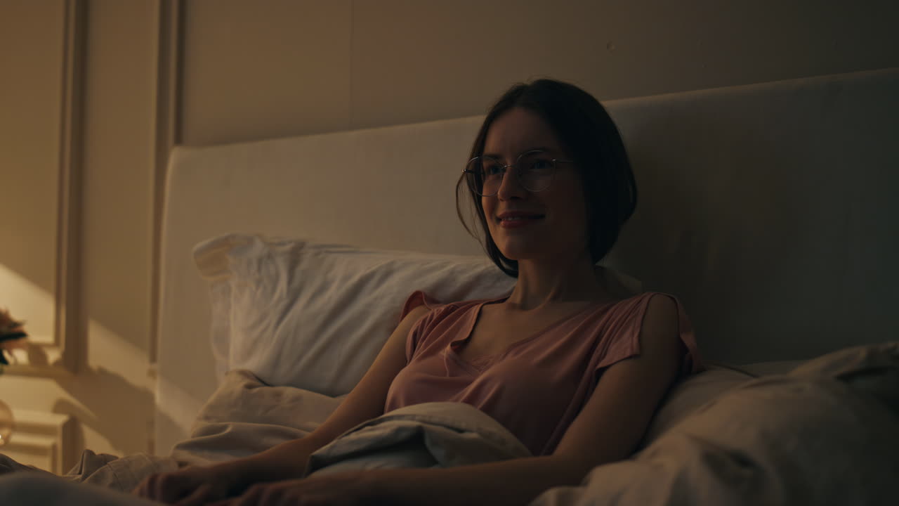 잠들기 전에 잠자리에 누워있는 미소 짓는 소녀, 편안한 집에서 꿈꾸는 즐거운 행복한 여성.