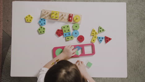 Draufsicht-Auf-Ein-Kleines-Mädchen,-Das-Mit-Einem-Formensortierer-In-Einer-Montessori-Schule-Spielt