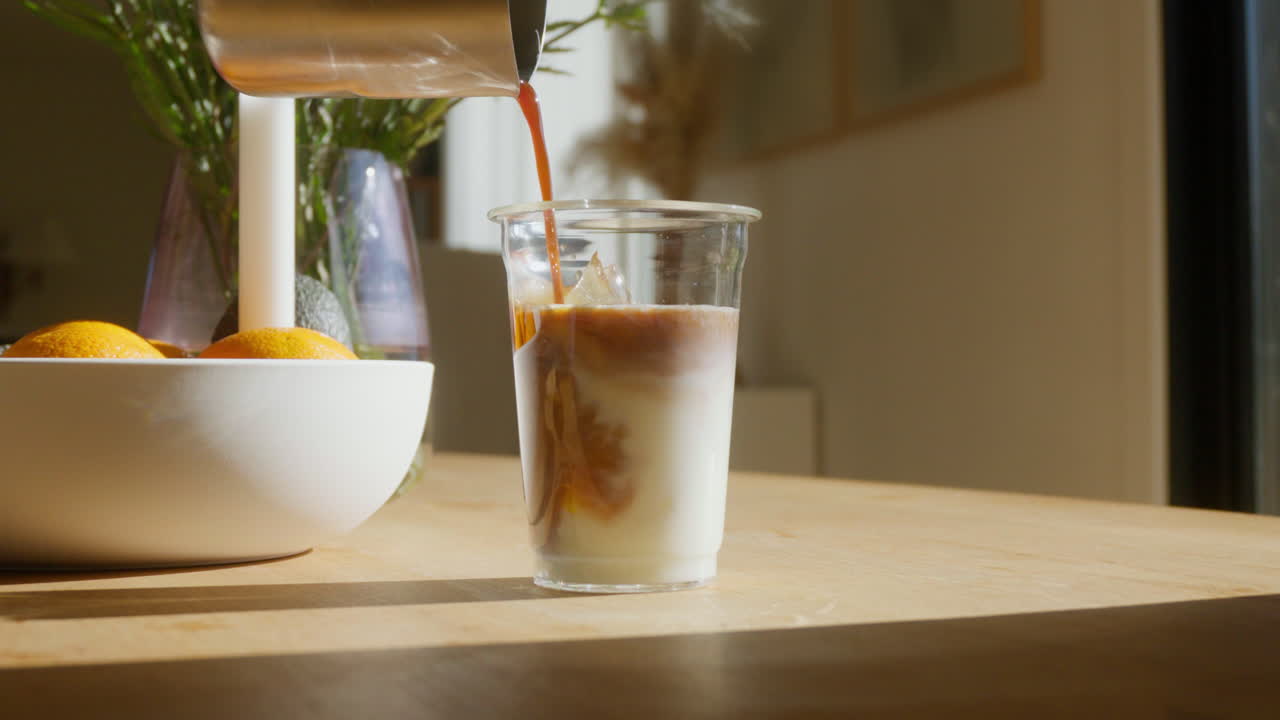 Versare caffè freddo in un bicchiere di latte