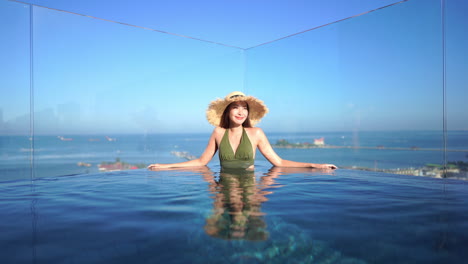 Ein-Süßes-Asiatisches-Mädchen,-Das-Sich-In-Einem-Swimmingpool-Mit-Meerblick-In-Einem-Boutique-Hotel-Entspannt