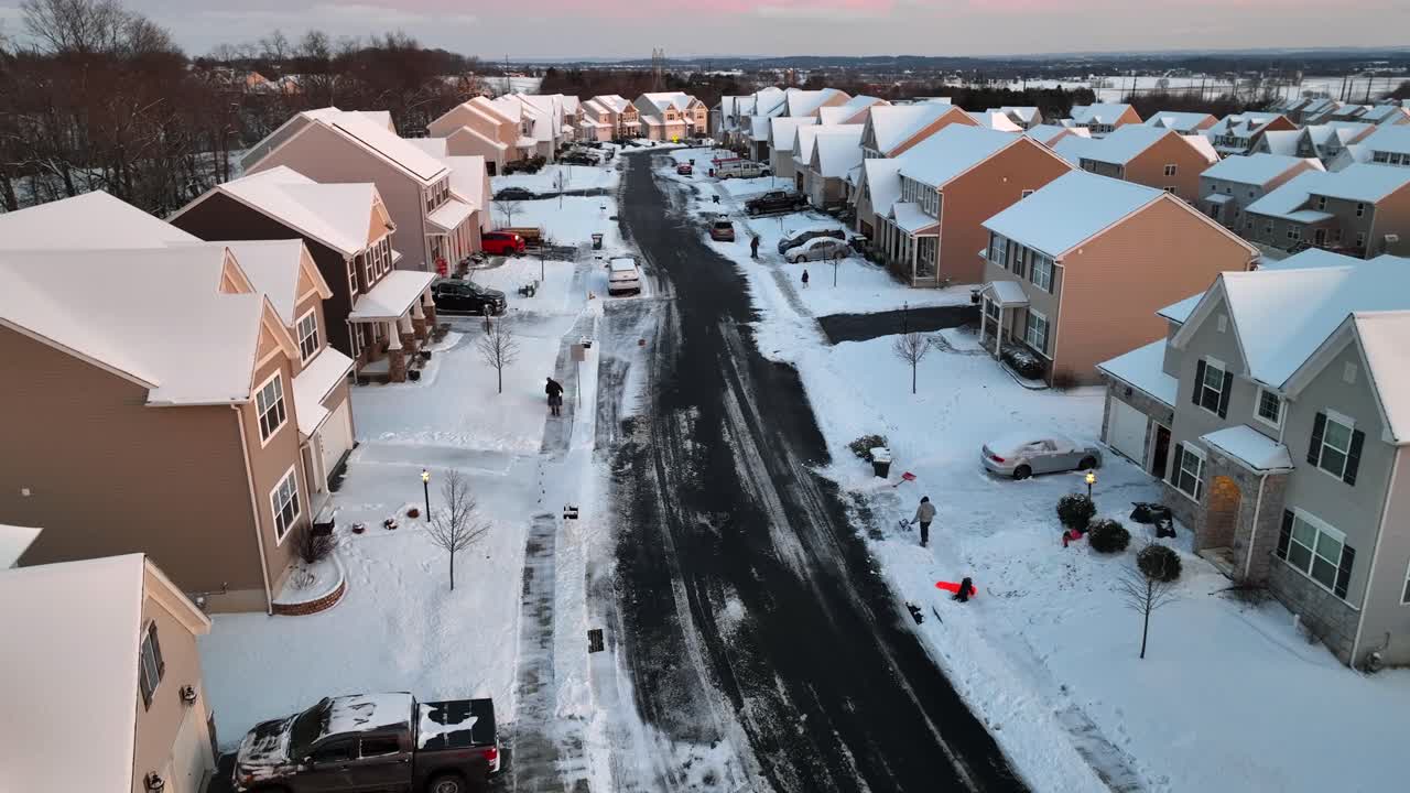 Family having fun on snow, father cleaning sidewalk with shovel