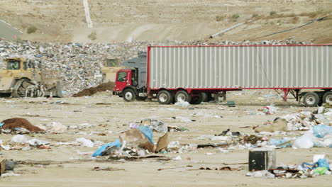 semi-truck at a landfill with piles of garbage