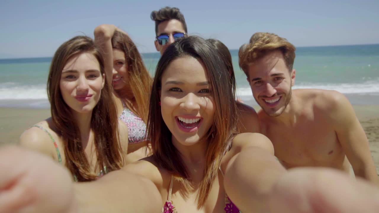 Gruppo di amici che si scattano un selfie su una spiaggia assolata