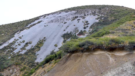 Panning-shot-of-green-and-sandy-mountains-against-bright-sky-in-Castle-Hill-National-Park,-New-Zealand