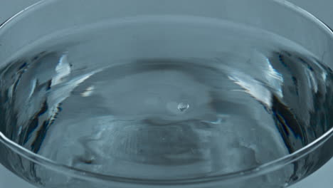 aqua blob splashed transparent liquid glass closeup. falling drop inside water