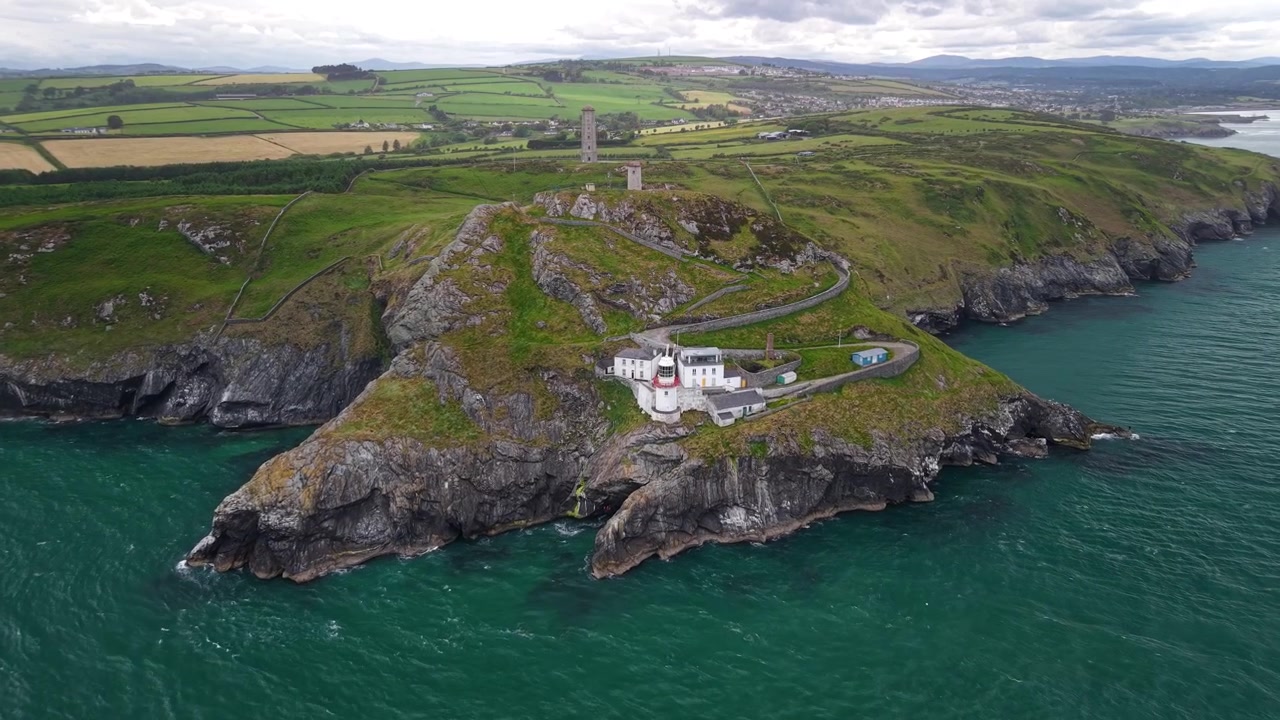 Antiguo Faro de Wicklow Head sobre acantilados escarpados y la pintoresca costa irlandesa, Condado de Wicklow
