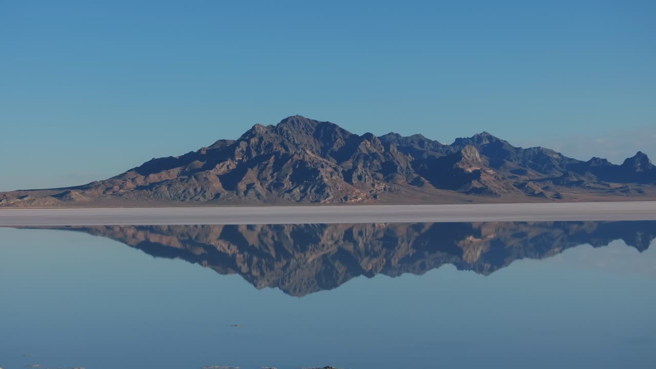 유타 주 보네빌 소금 평야 (bonneville salt flats) 의 물에 잠긴 표면에 반사되는 바위 산
